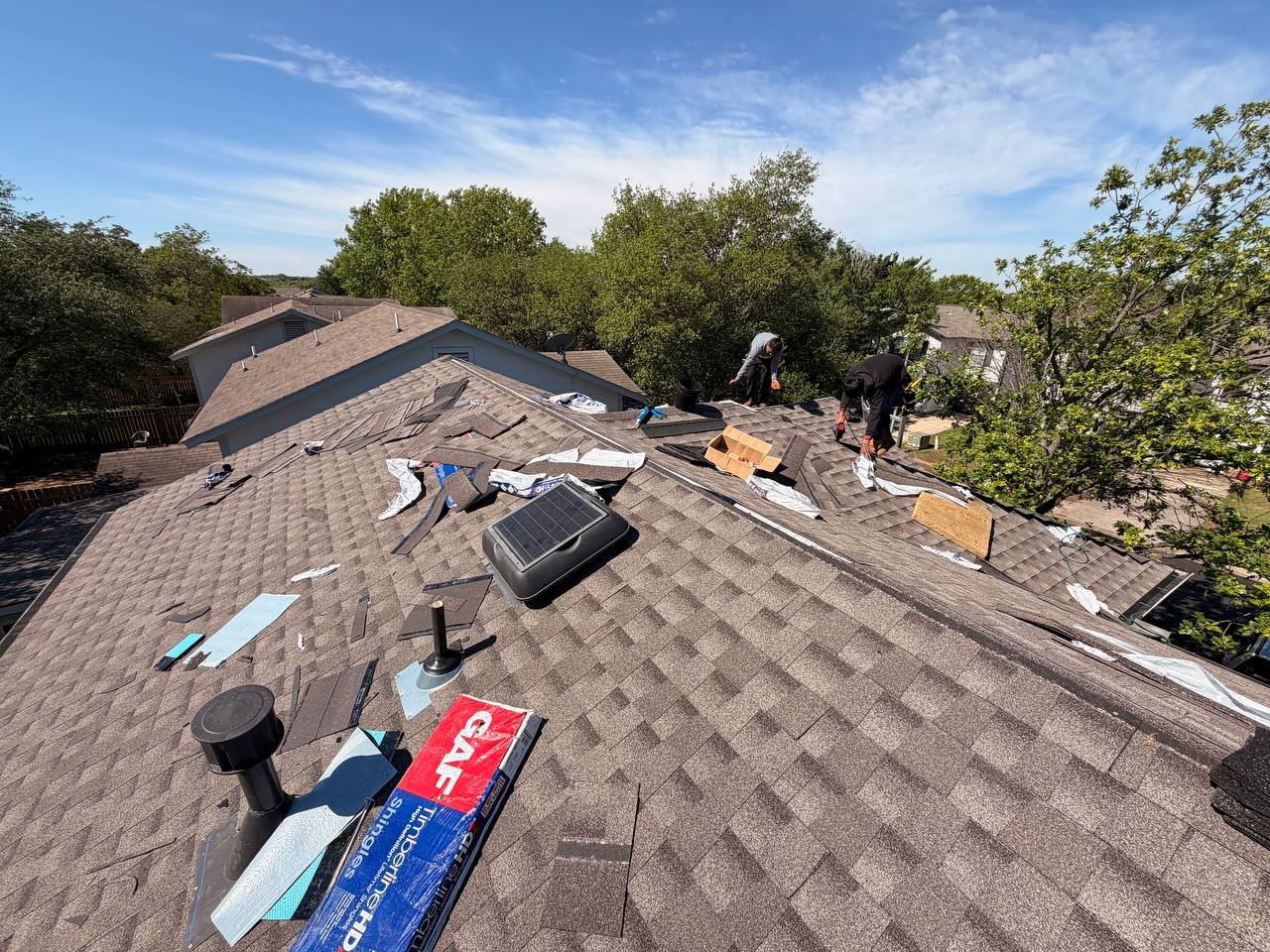 Roofer inspecting a Texas roof during routine maintenance