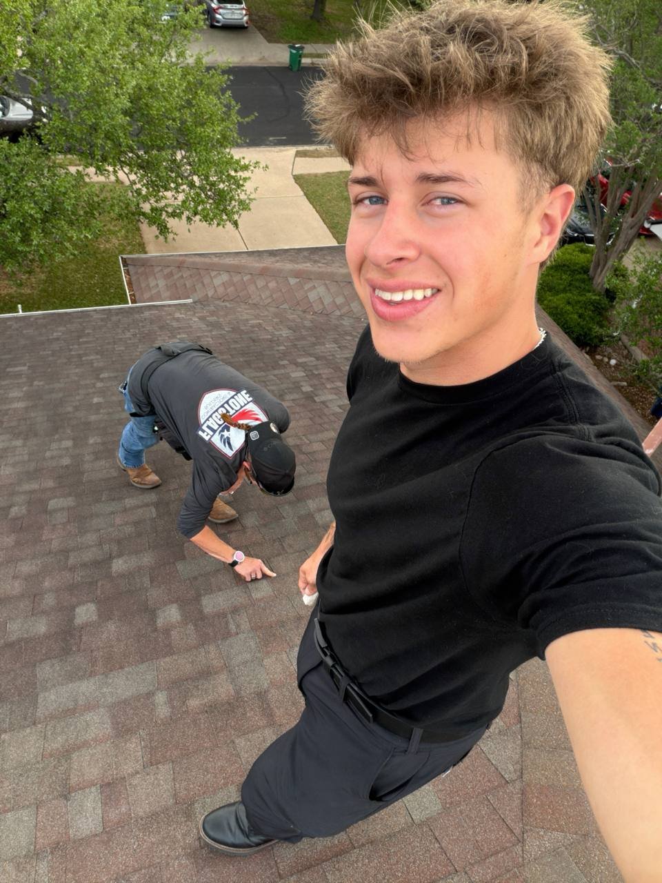 Roofing sales rep photographing hail damage on a shingle roof in Texas