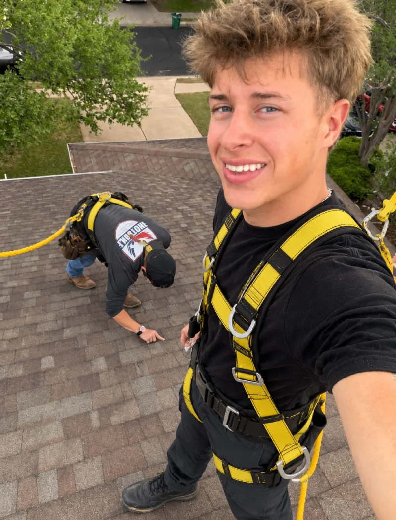 Roofing sales rep photographing hail damage on a shingle roof in Texas